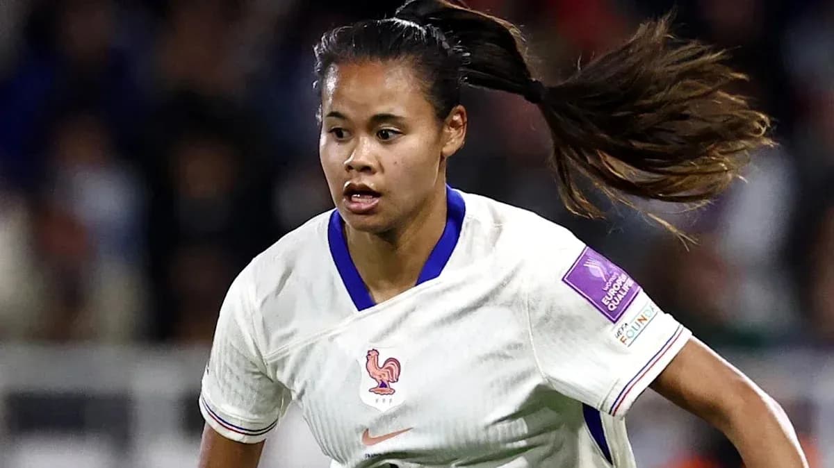 Jugadora de fútbol de Francia corriendo con el balón
