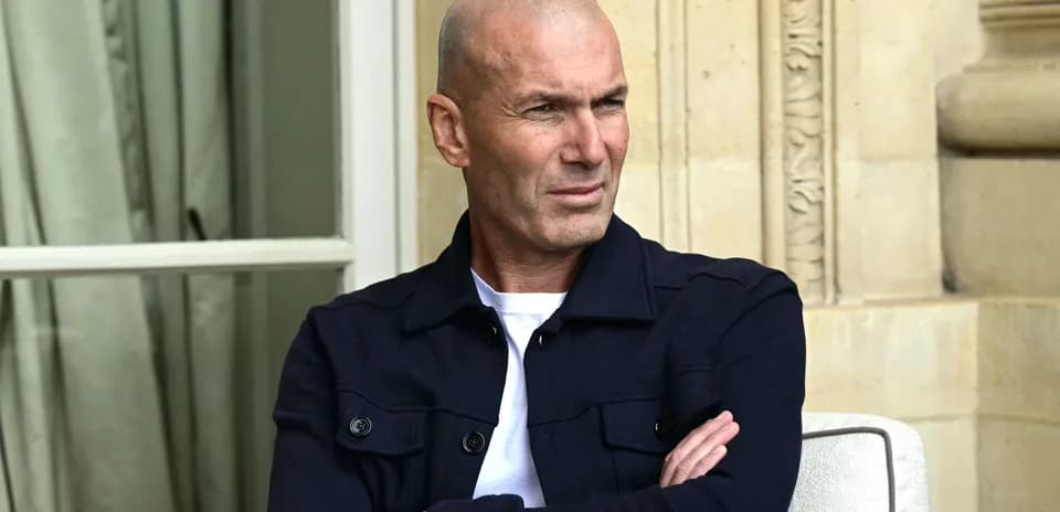 Hombre con chaqueta oscura sentado con los brazos cruzados