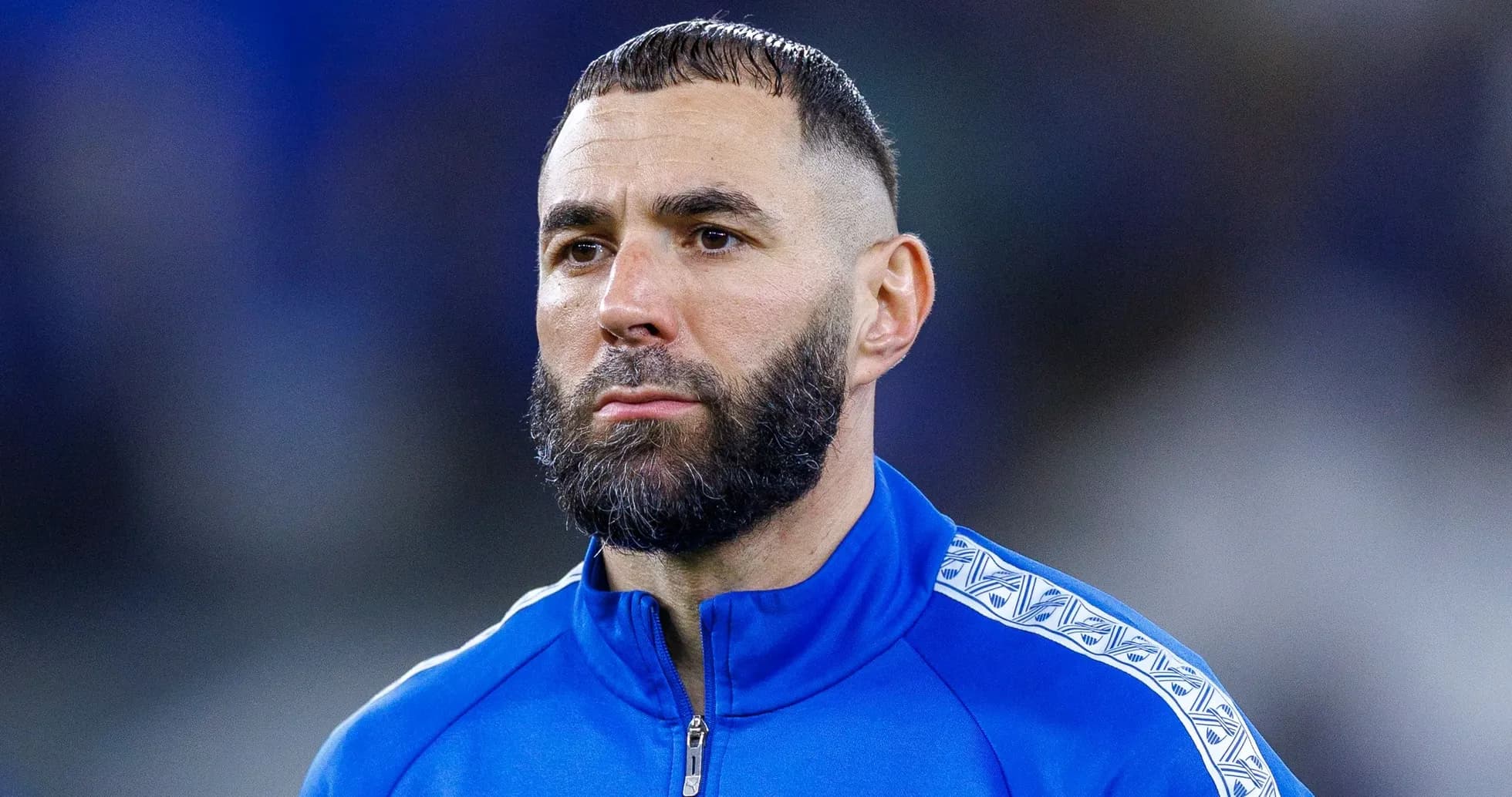Jugador de fútbol en chaqueta azul antes del partido