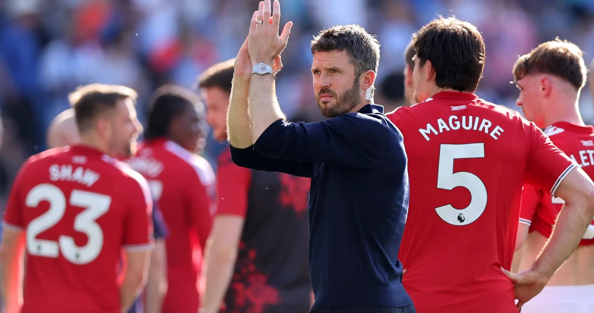 Entrenador aplaudiendo junto a jugadores de Manchester United