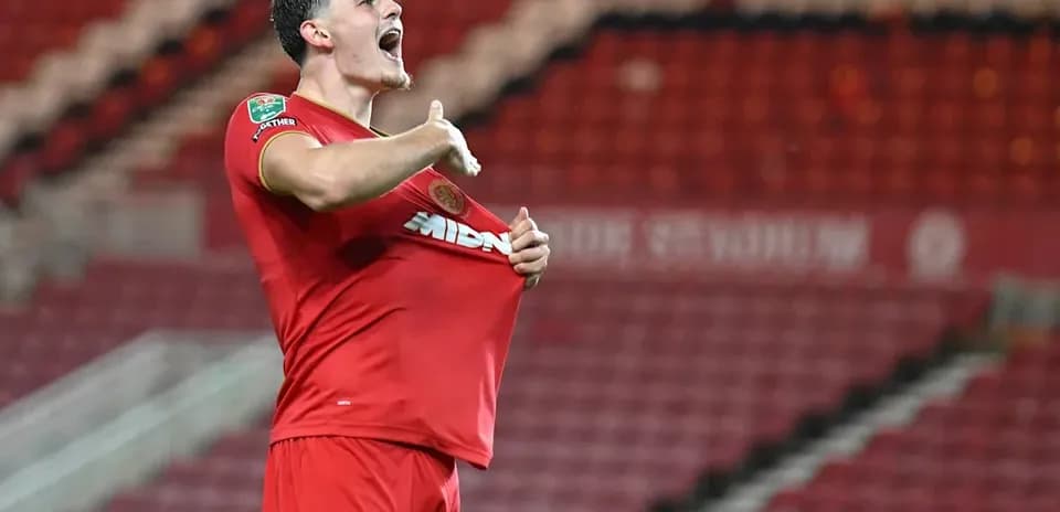 Jugador celebrando y mostrando su camiseta en el estadio