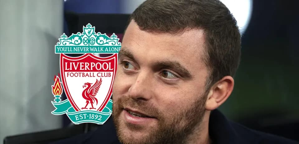 Hombre con barba junto al escudo de Liverpool FC