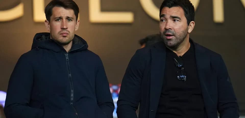 Dos hombres sentados en la grada del estadio