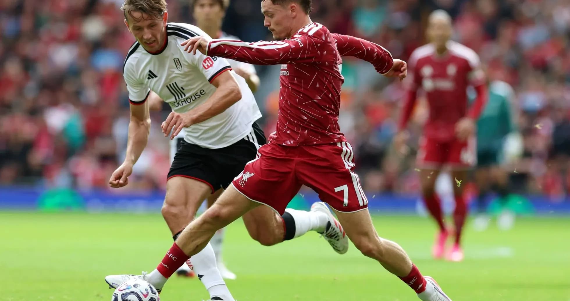Jugador de Liverpool y Fulham compitiendo por el balón