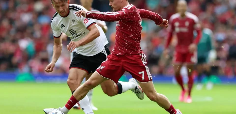 Jugador de Liverpool y Fulham compitiendo por el balón