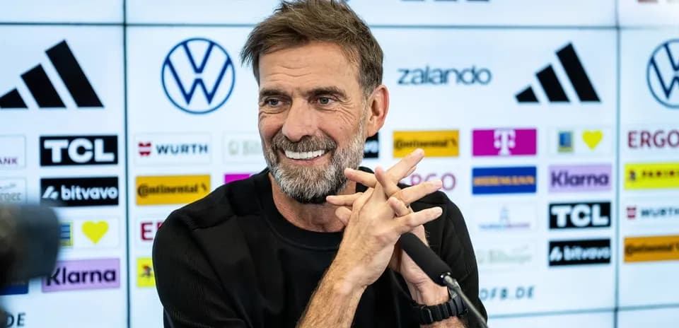 Entrenador en conferencia de prensa sonriente