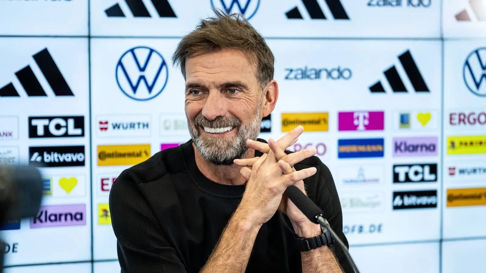 Entrenador en conferencia de prensa sonriente