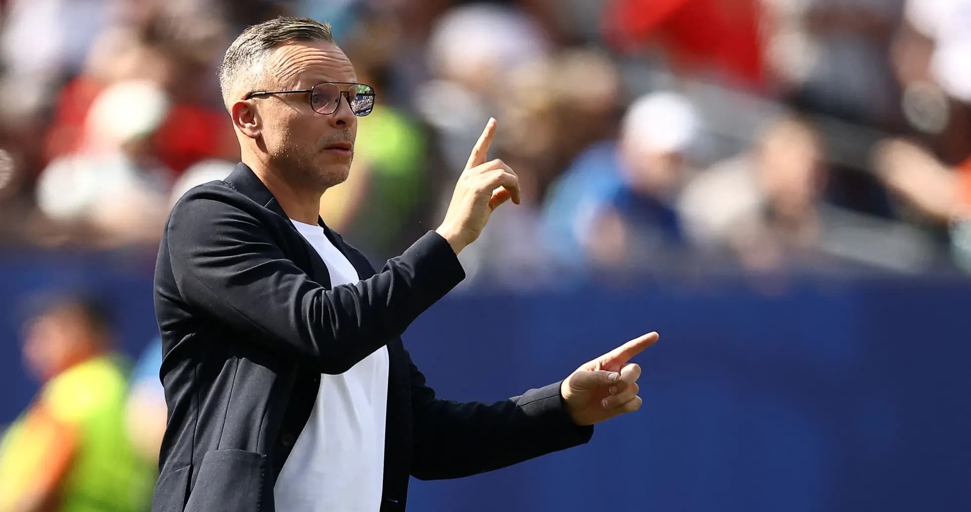 Entrenador gesticulando durante un partido de fútbol