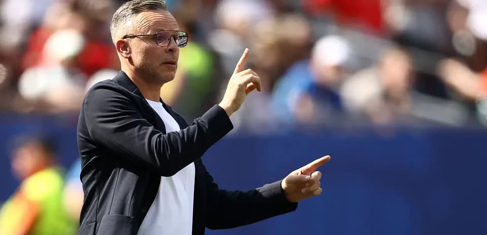 Entrenador gesticulando durante un partido de fútbol