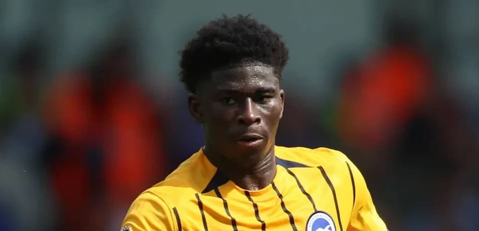 Jugador corriendo en uniforme de Brighton & Hove Albion