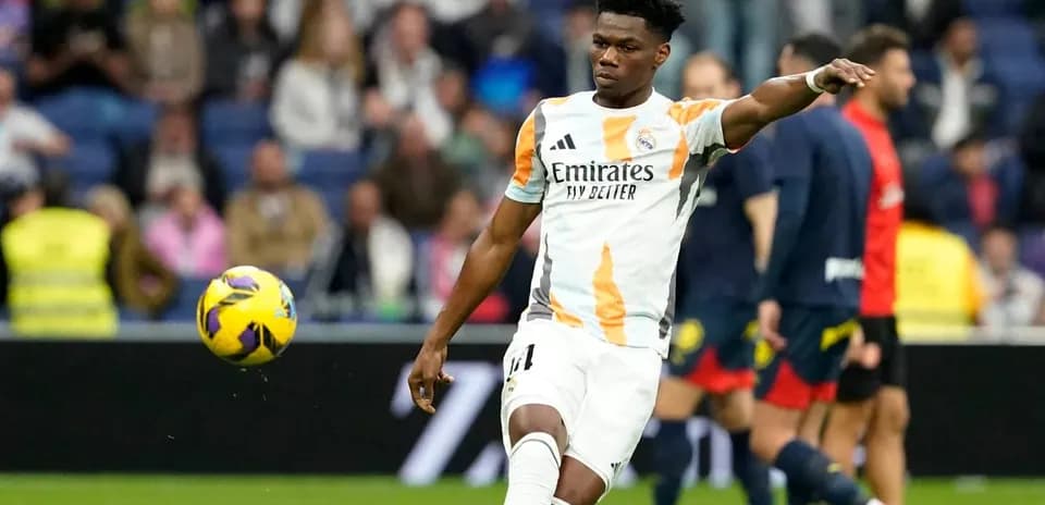 Jugador de Real Madrid lanzando el balón en el campo
