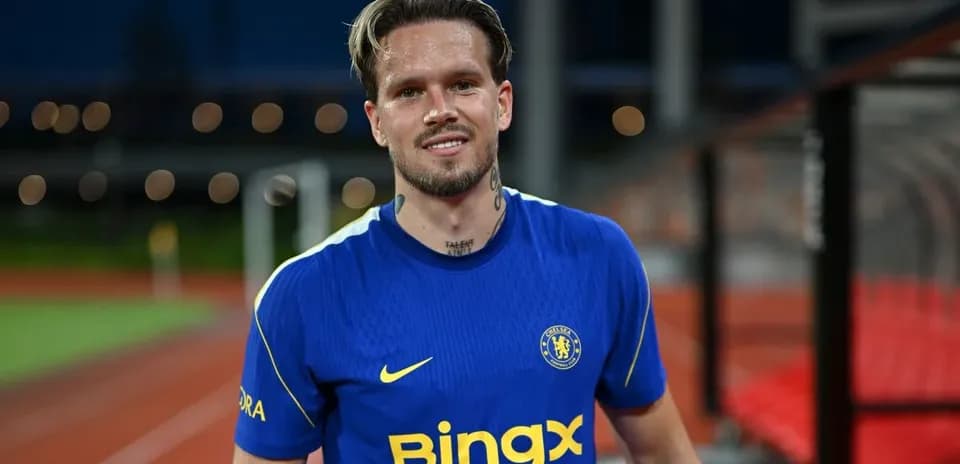 Jugador sonriendo con camiseta de Chelsea en el campo