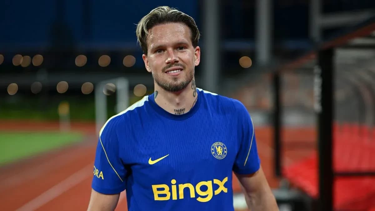 Jugador sonriendo con camiseta de Chelsea en el campo