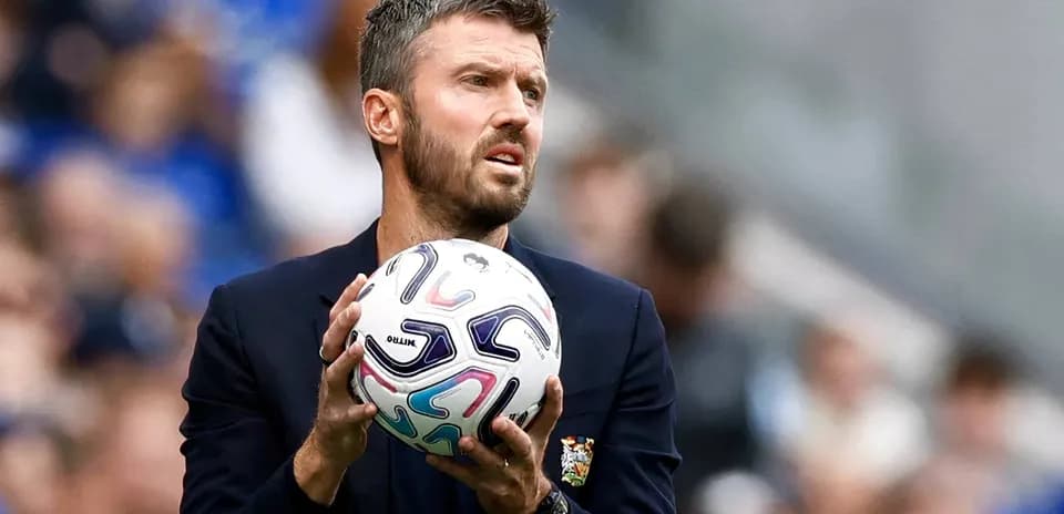 Entrenador sosteniendo un balón durante un partido