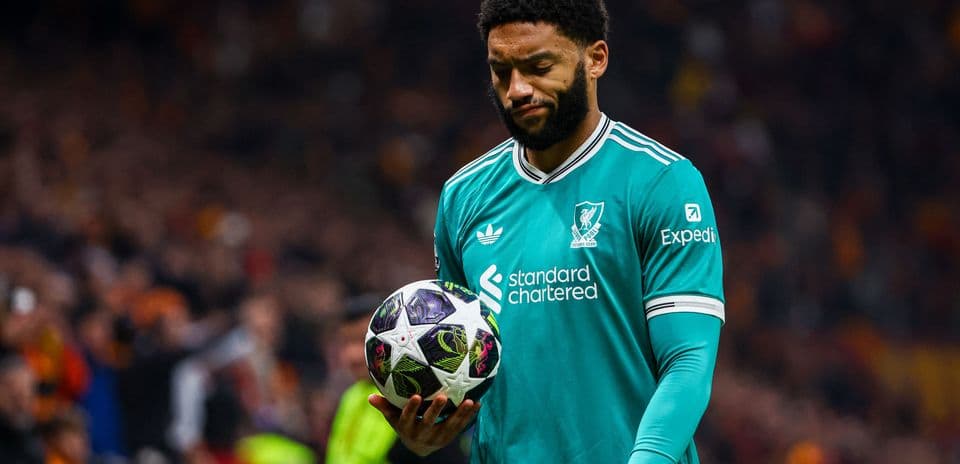 Jugador de Liverpool sosteniendo un balón en el campo