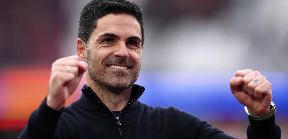 Entrenador sonriendo con puños en alto durante celebración
