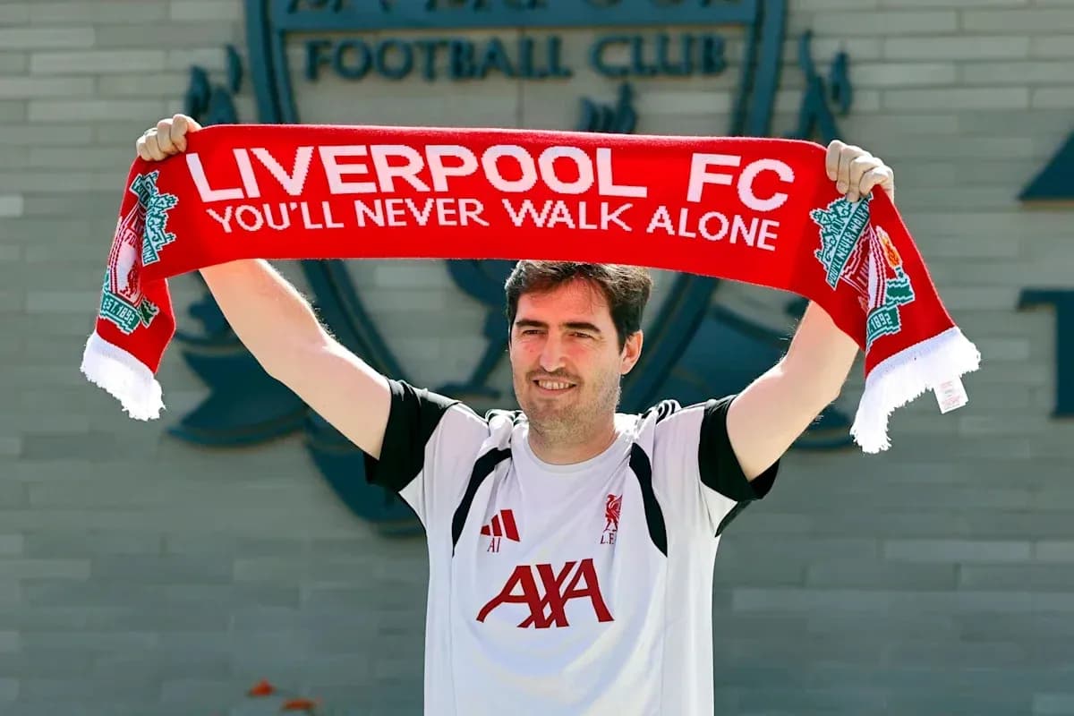 Jugador sosteniendo bufanda de Liverpool FC