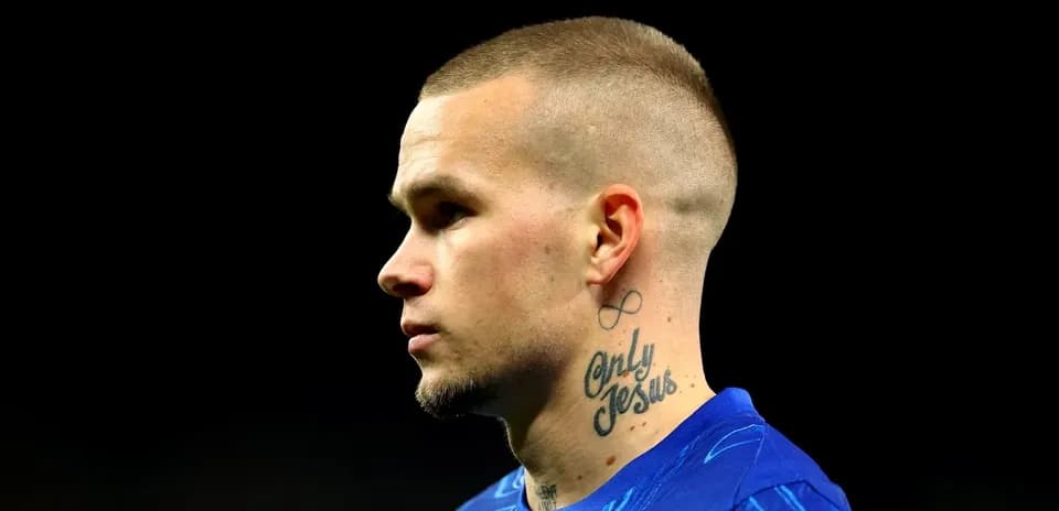 Jugador con tatuajes en el cuello y camiseta azul