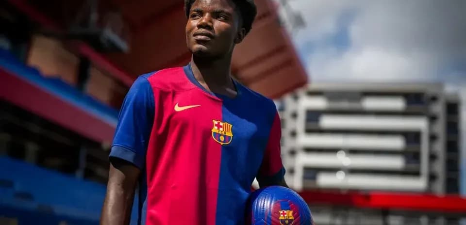 Jugador de fútbol con balón en el estadio