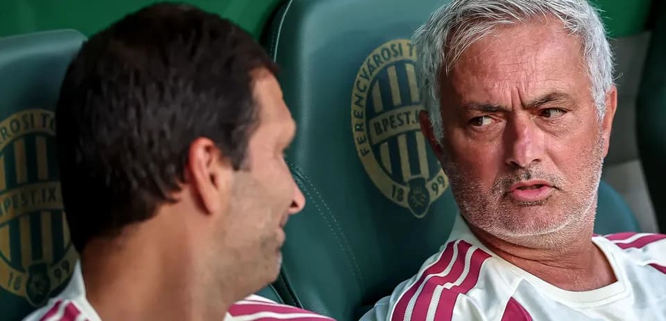 Entrenador conversando con jugador en banco de suplentes