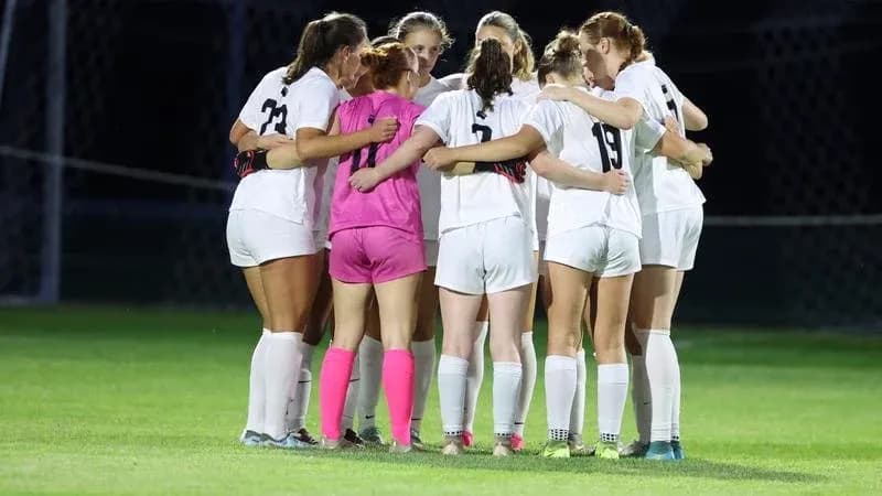 Equipo femenino de fútbol formando un círculo