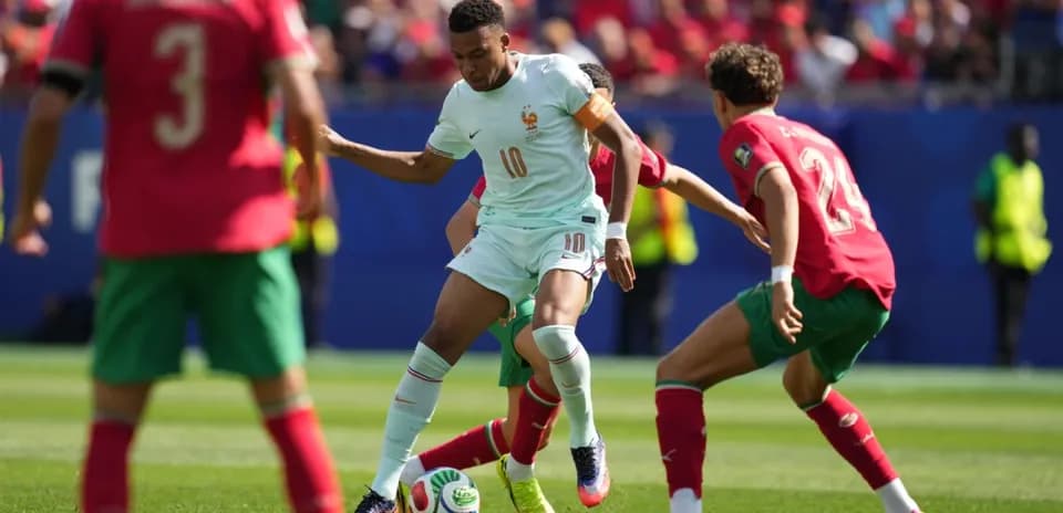Jugador de Francia esquivando a dos rivales de Marruecos