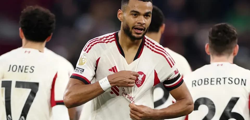 Jugador de Liverpool señalando su camiseta durante el partido