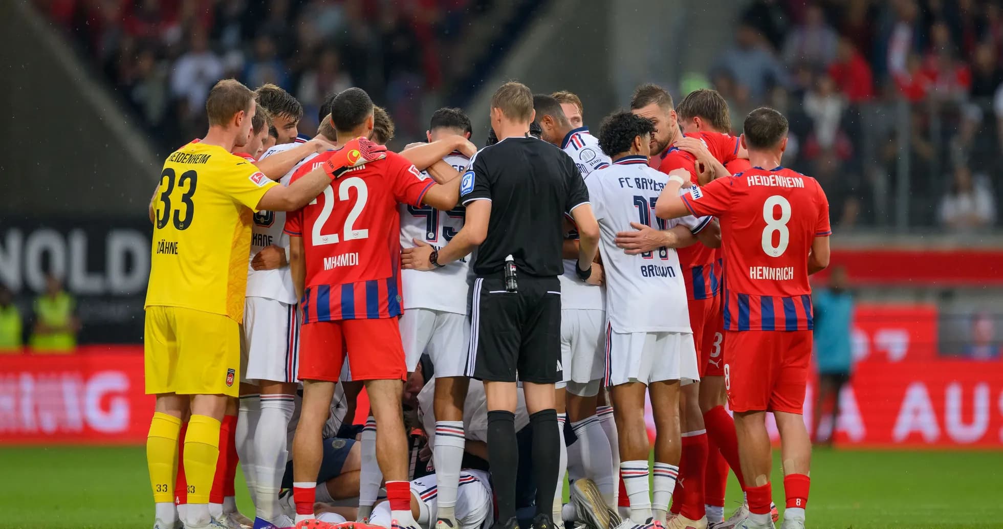 Jugadores de ambos equipos en círculo durante el partido