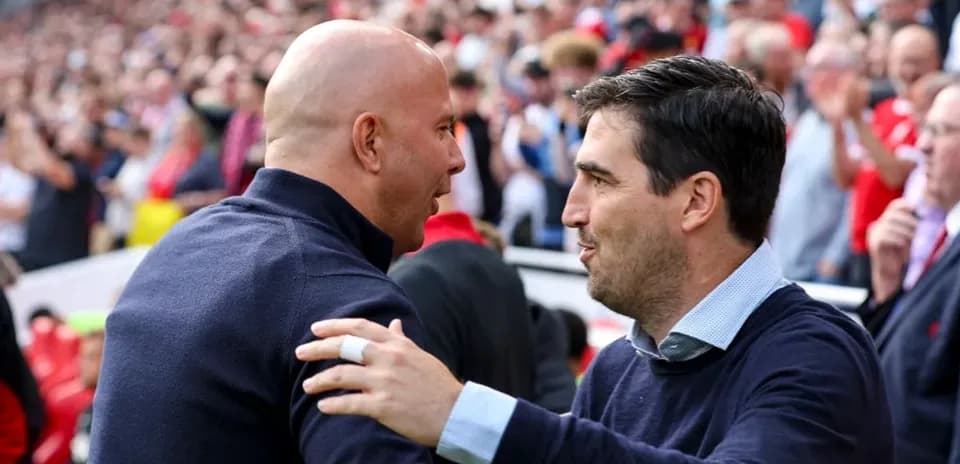 Entrenadores saludándose en el estadio durante el partido