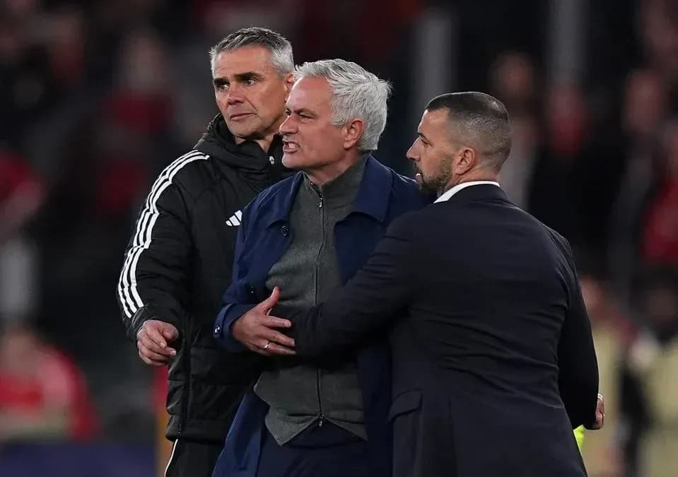 Entrenador siendo contenido por asistentes durante partido