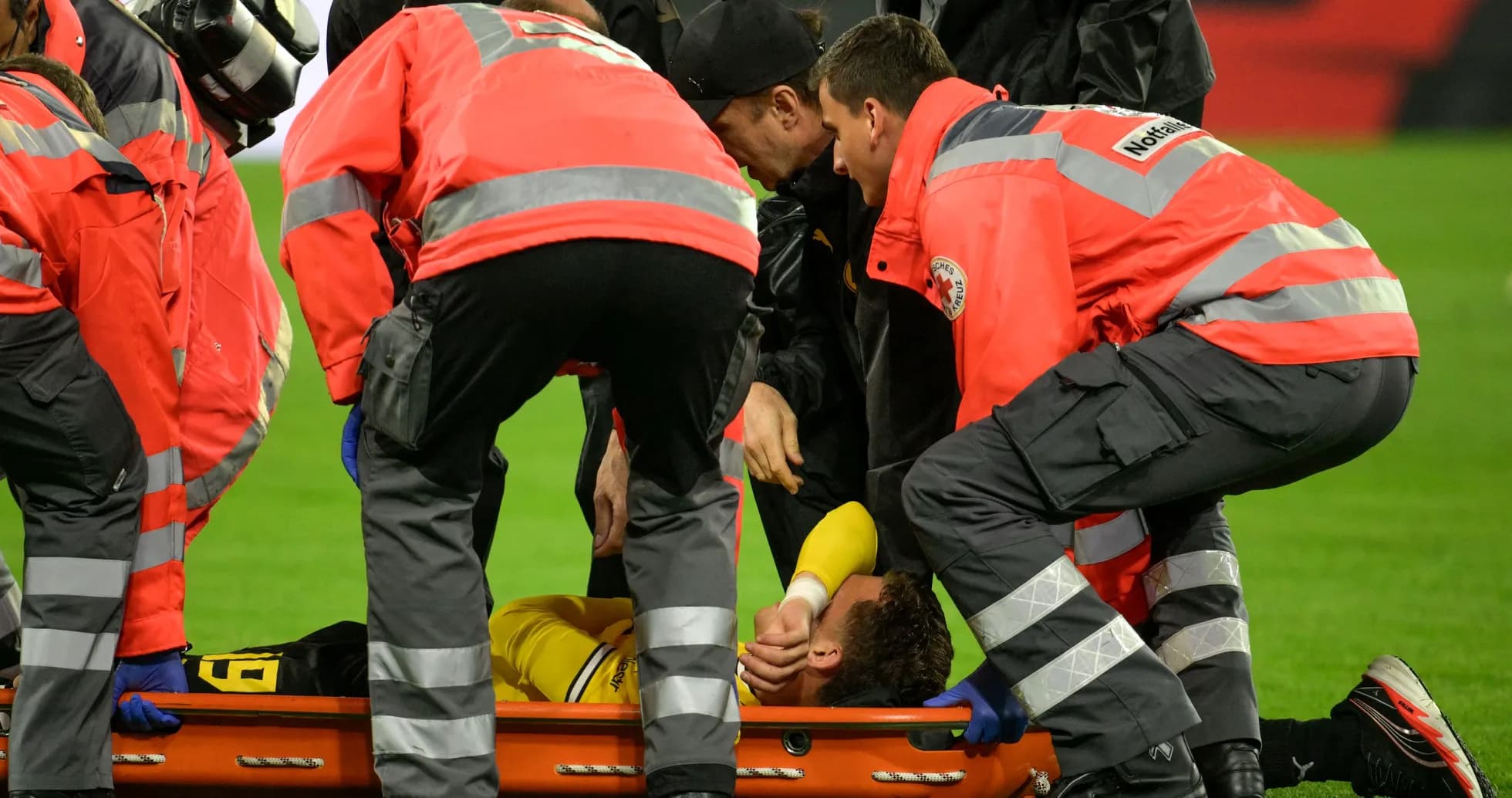 Personal médico atendiendo a jugador en camilla