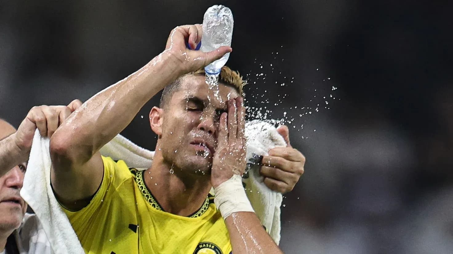 Jugador recibiendo agua en la cara durante el partido