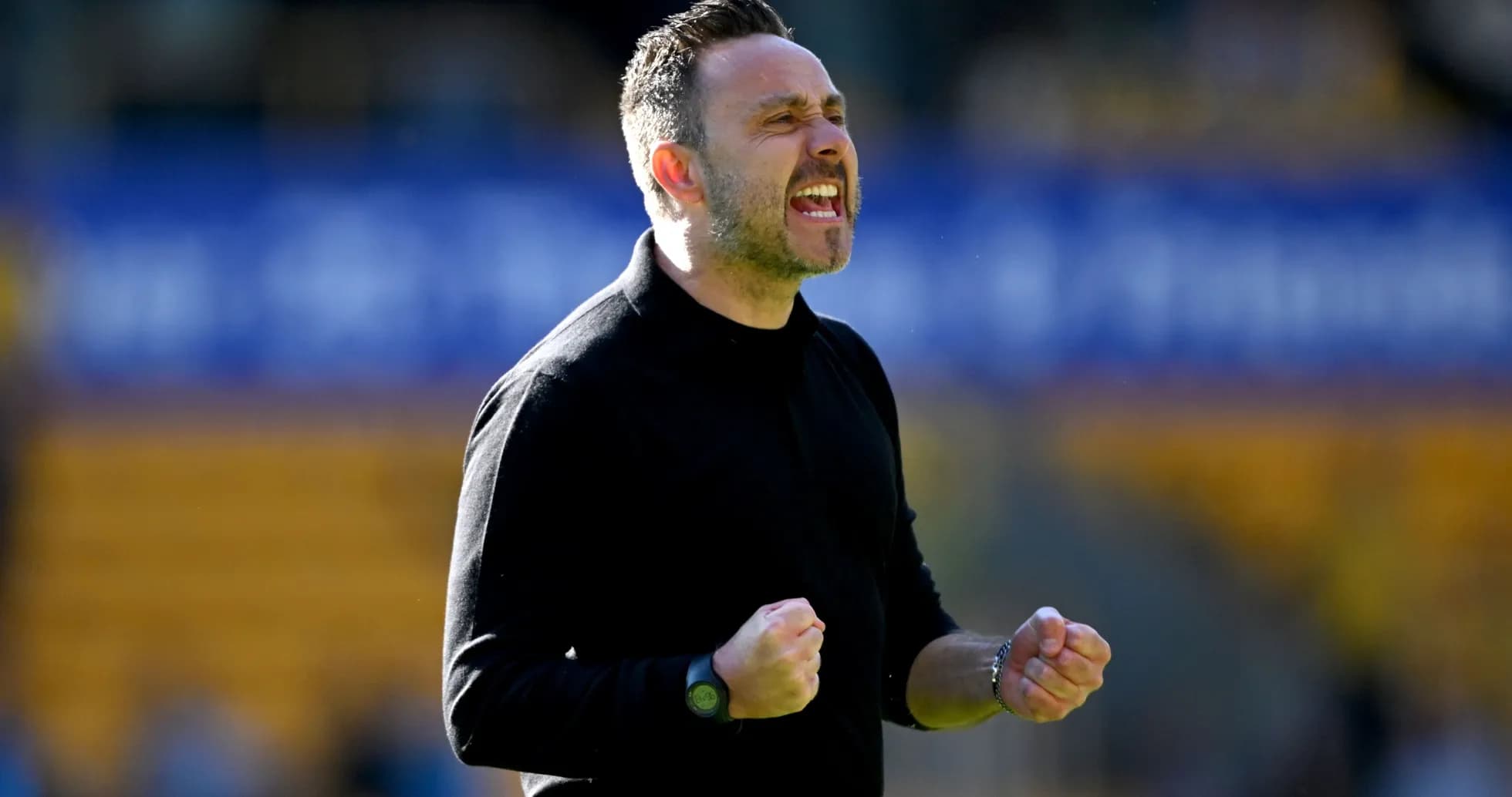 Entrenador celebrando con los puños cerrados en el campo