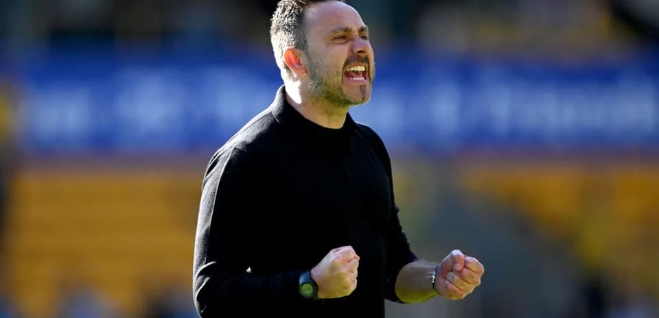 Entrenador celebrando con los puños cerrados en el campo