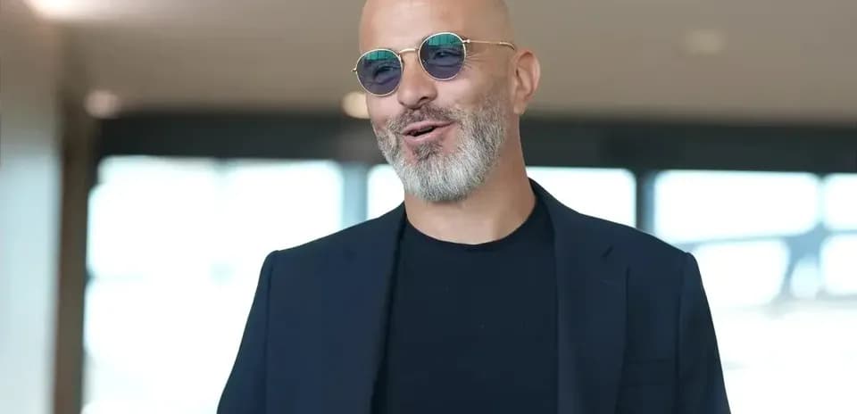 Hombre con barba y gafas de sol sonriendo