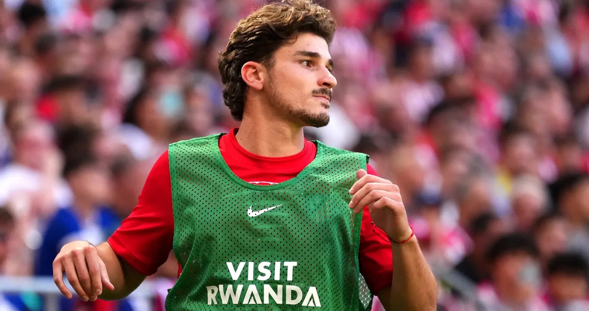 Jugador en el banquillo con chaleco verde