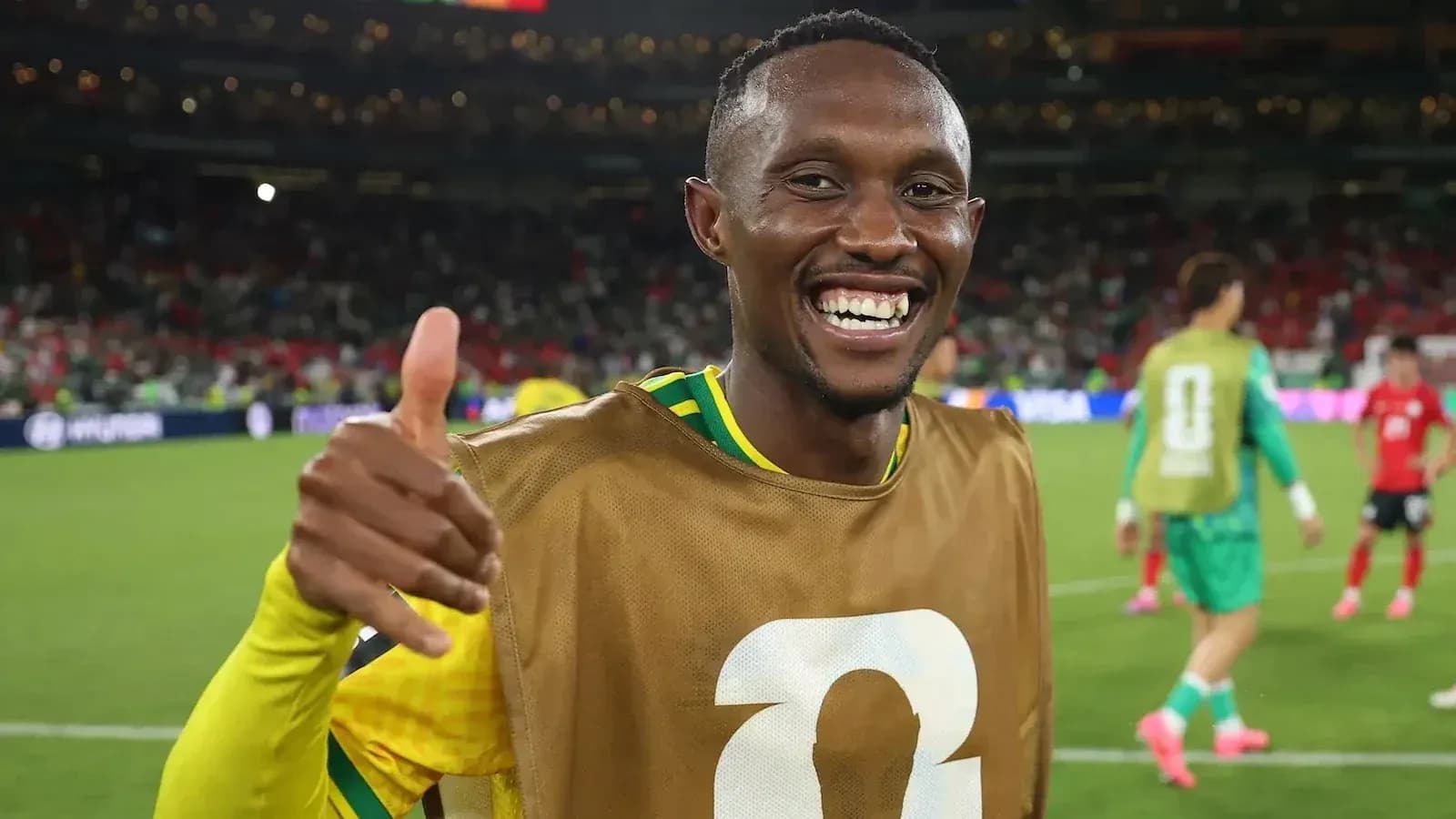 Jugador sonriendo y haciendo gesto de aprobación en campo