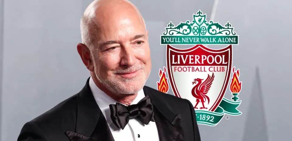 Hombre sonriente con logo de Liverpool detrás