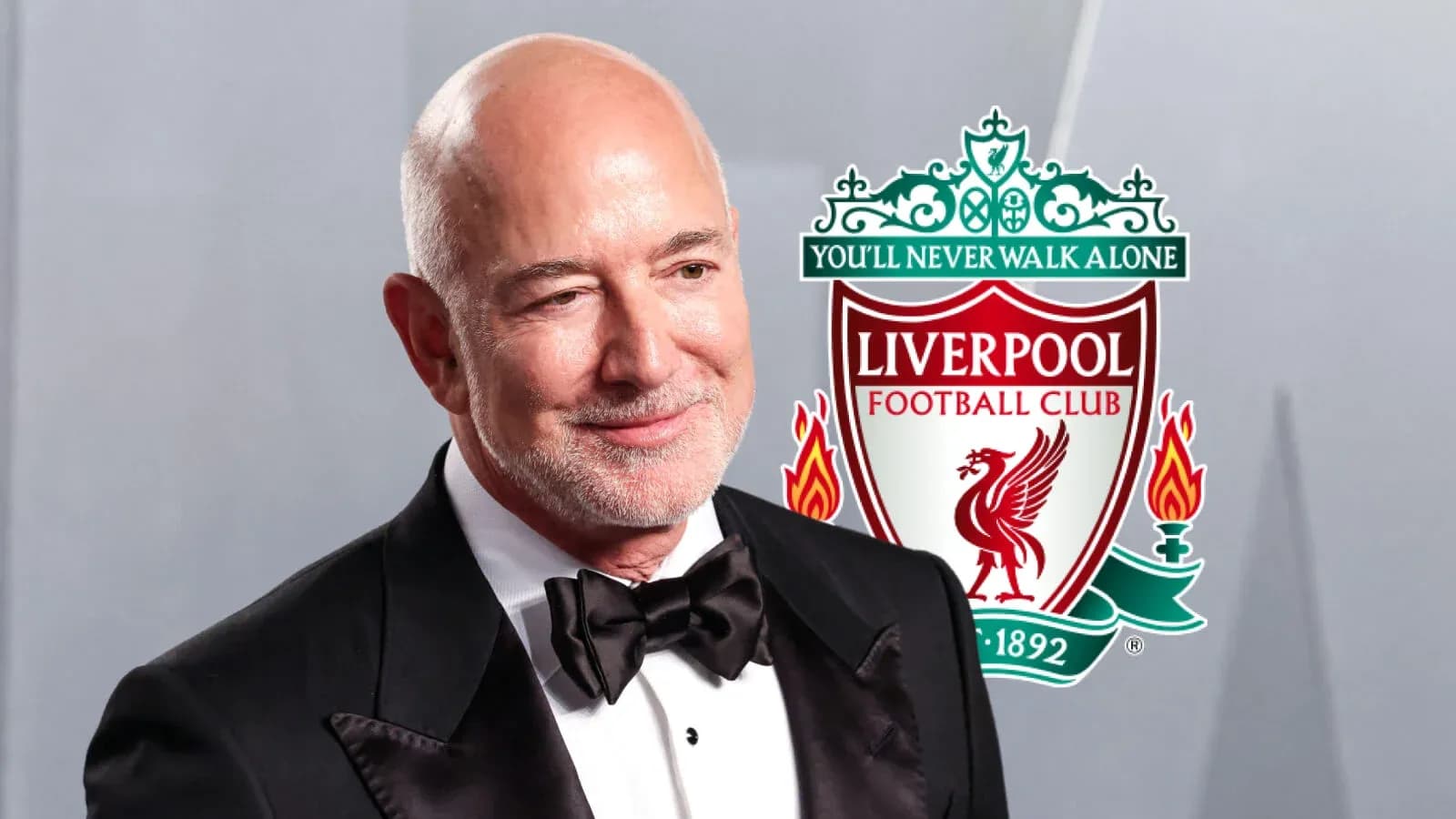 Hombre sonriente con logo de Liverpool detrás