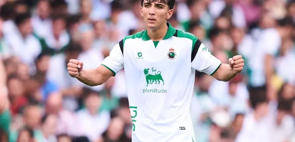 Jugador celebrando en el campo con aficionados detrás