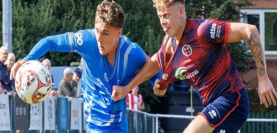 Jugador en camiseta azul luchando por el balón