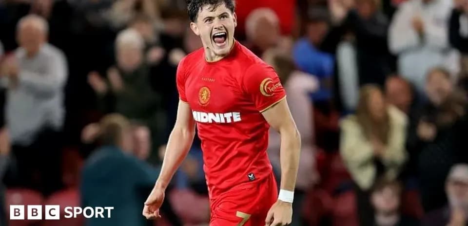 Jugador celebrando con camiseta roja en estadio