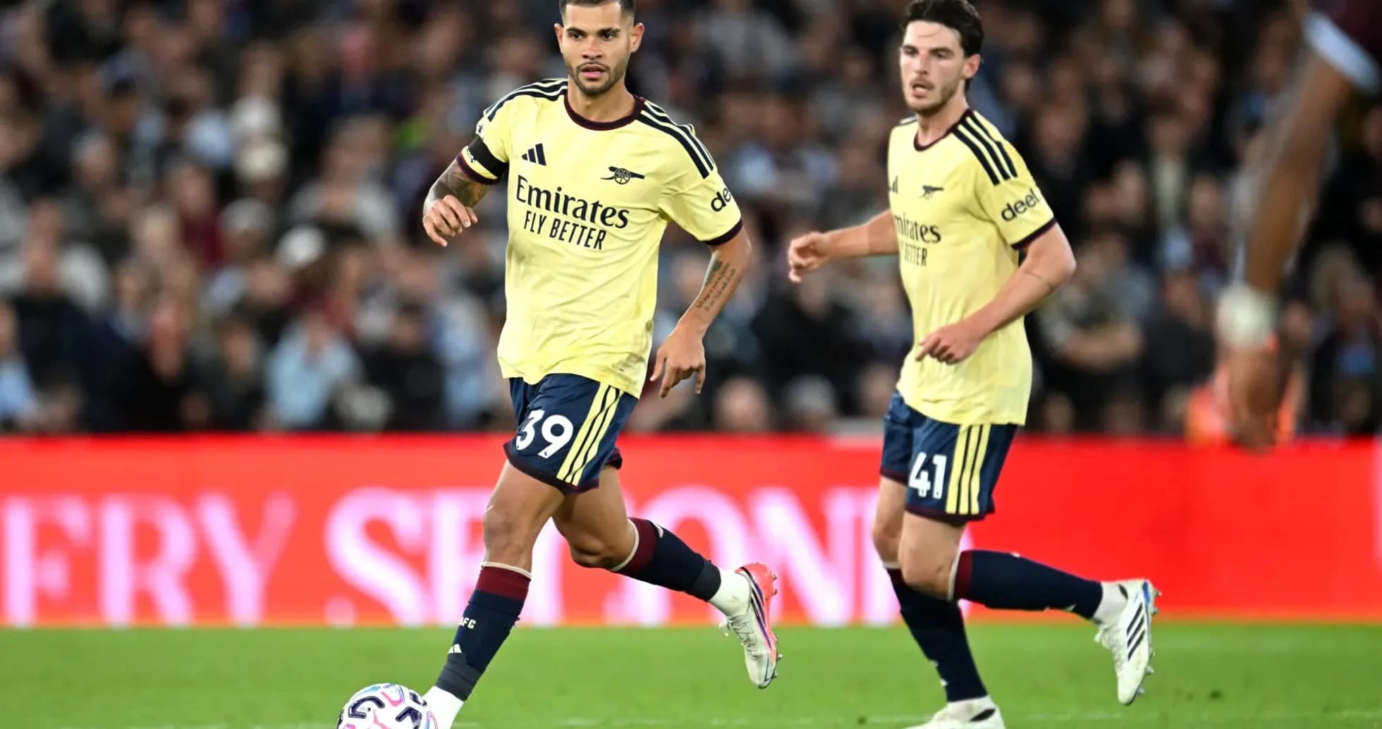 Jugadores de Arsenal corriendo con balón en partido
