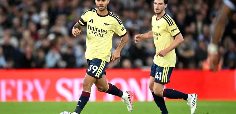 Jugadores de Arsenal corriendo con balón en partido
