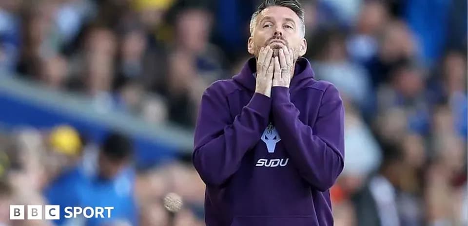 Entrenador preocupado en el banquillo durante partido