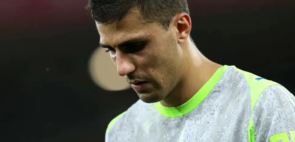 Jugador de fútbol con camiseta de entrenamiento, mirando hacia abajo