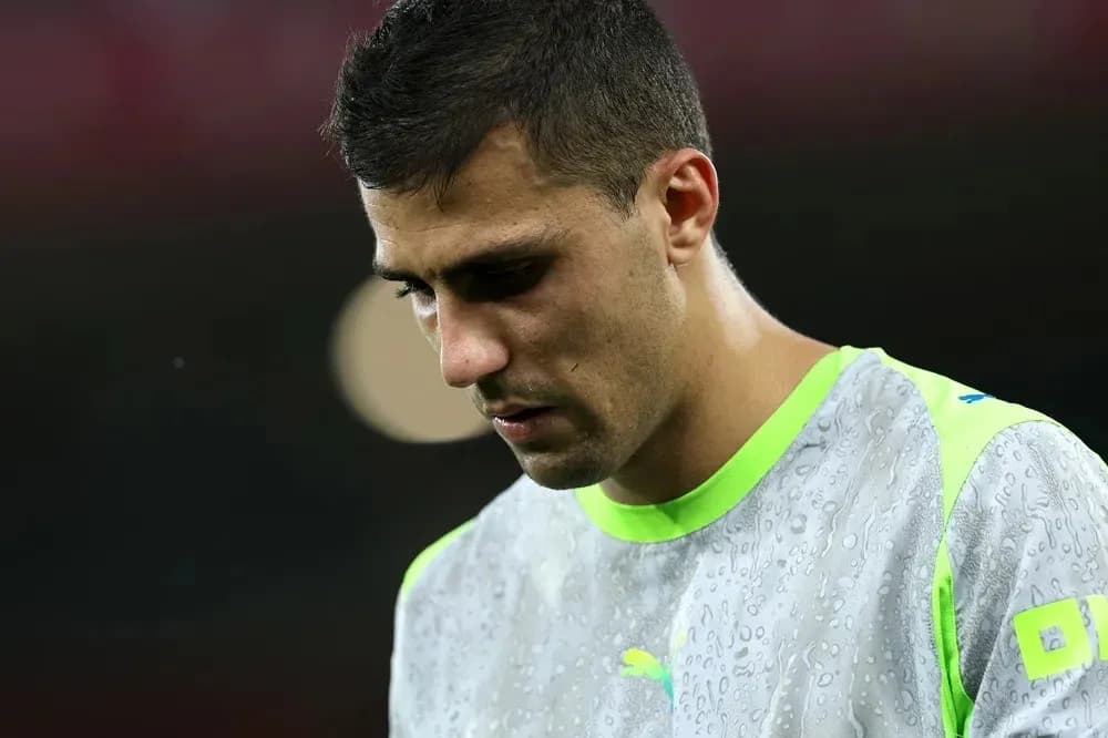 Jugador de fútbol con camiseta de entrenamiento, mirando hacia abajo