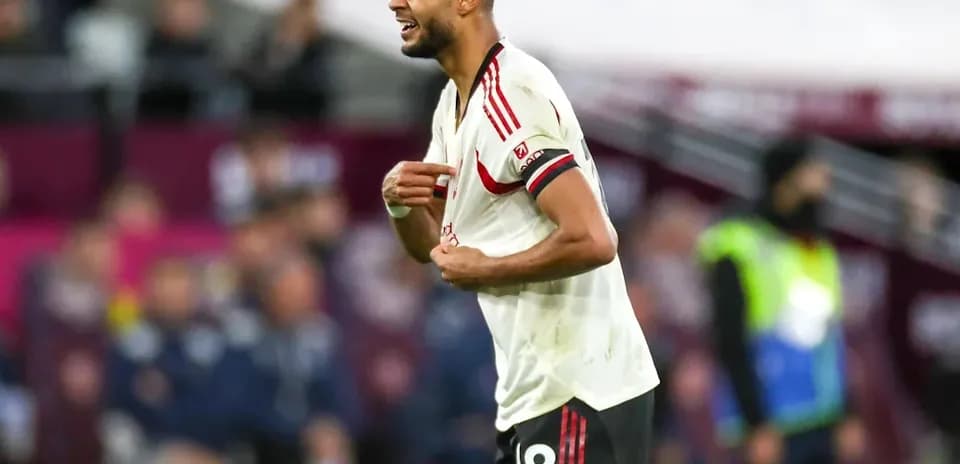 Jugador de fútbol sosteniendo su camiseta durante el partido