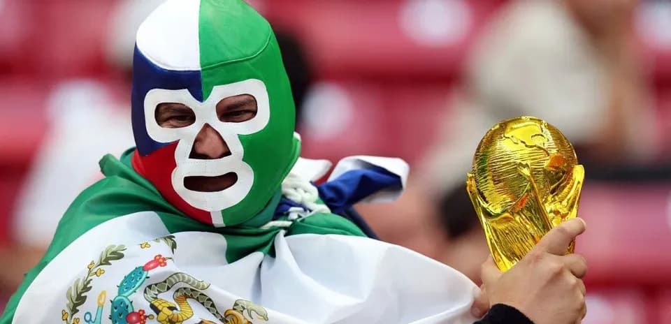 Afanático con máscara sostiene trofeo de la Copa del Mundo
