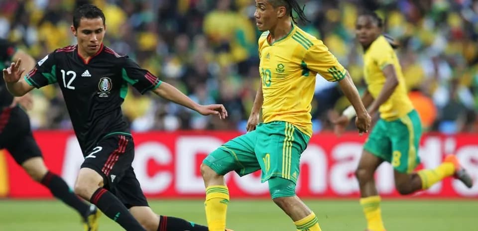 Jugadores de Sudáfrica y México compitiendo por el balón